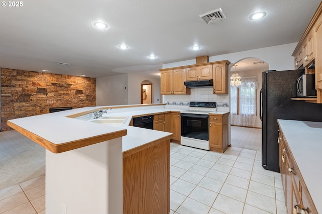 kitchen featuring black appliances, sink, decorative backsplash, light tile patterned floors, and a kitchen bar