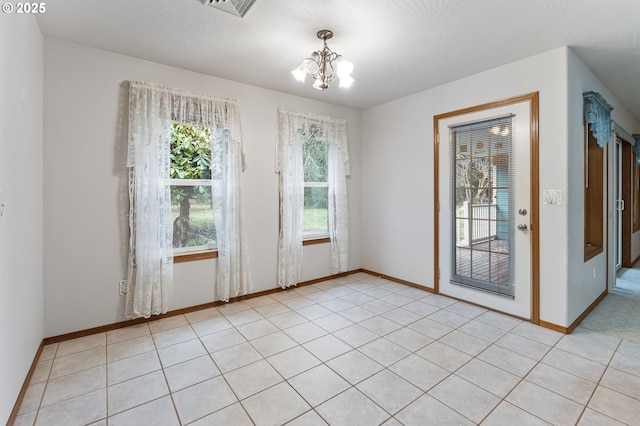 interior space with a notable chandelier and light tile patterned flooring