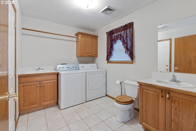 laundry room featuring washing machine and dryer, sink, and light tile patterned flooring