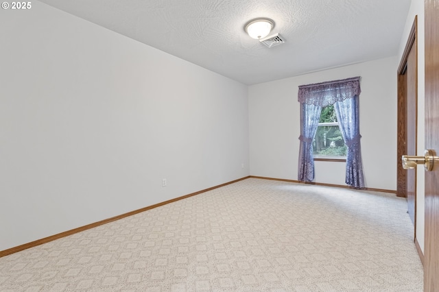 unfurnished room with a textured ceiling and light carpet