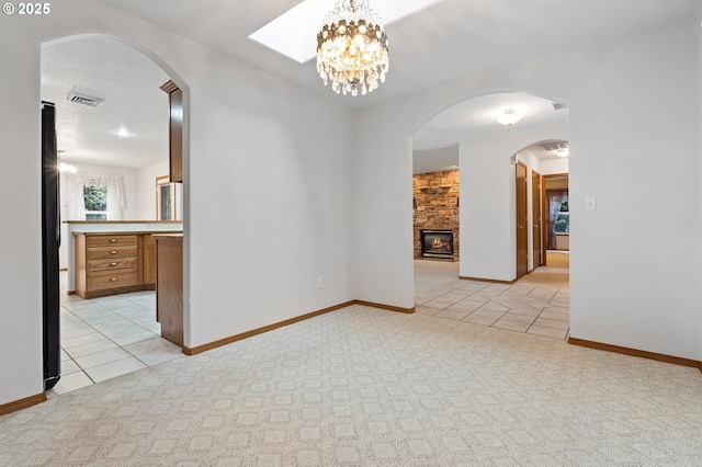 interior space with a stone fireplace and a chandelier