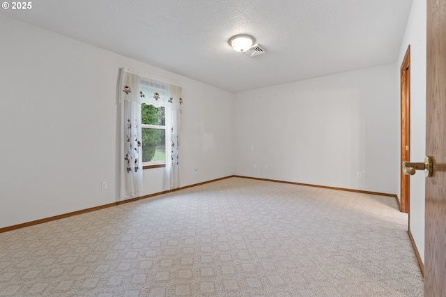 carpeted empty room with a textured ceiling