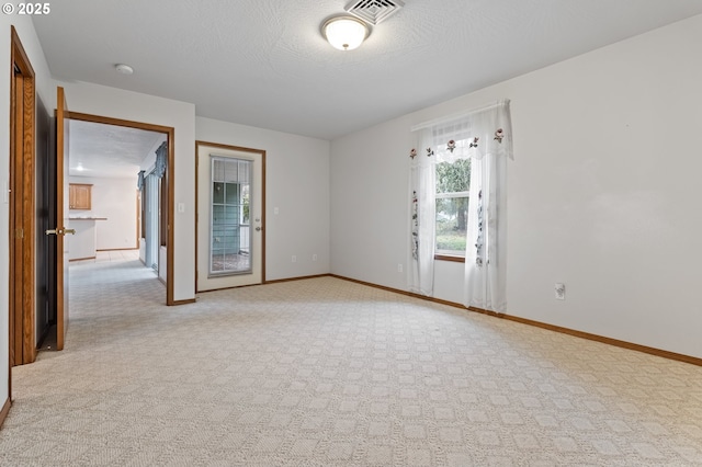 carpeted spare room featuring a textured ceiling