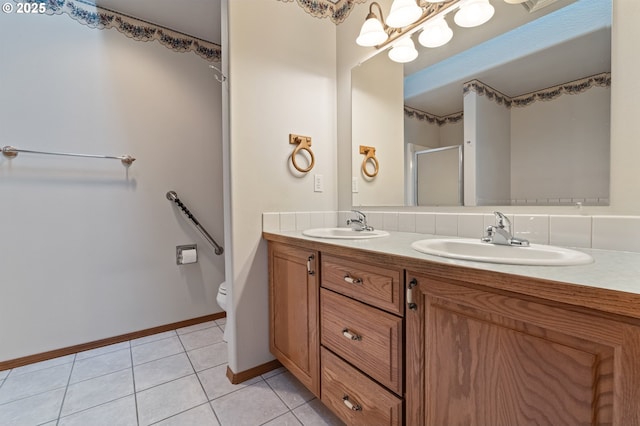 bathroom with toilet, vanity, tile patterned floors, and a shower with door