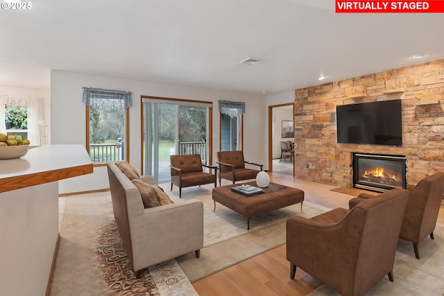 living room with a fireplace and light wood-type flooring