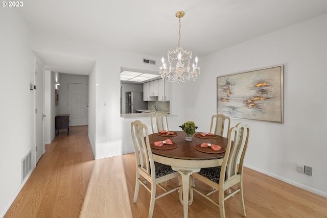 dining room with a chandelier and light hardwood / wood-style floors