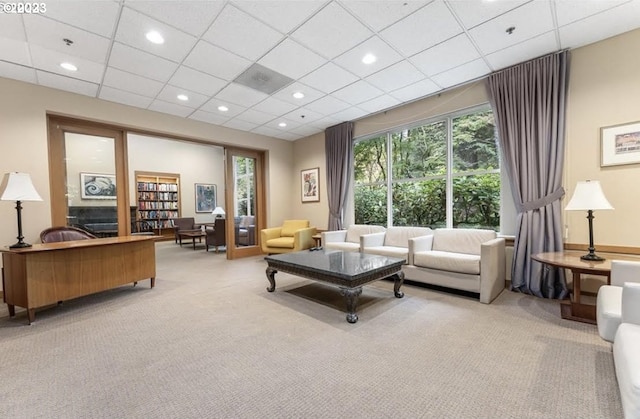 carpeted living room with a drop ceiling