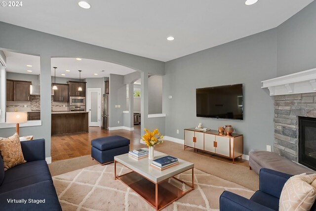 living room featuring a fireplace and light wood-type flooring