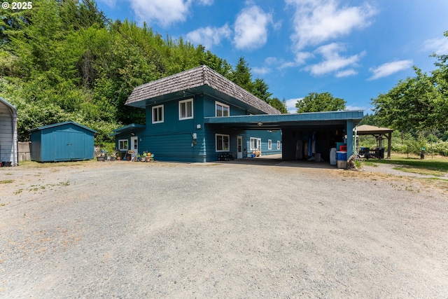 93777 Green Acres Ln, Coos Bay, OR 97420 - view of front of home featuring a carport, mansard roof, a storage unit, and dirt driveway