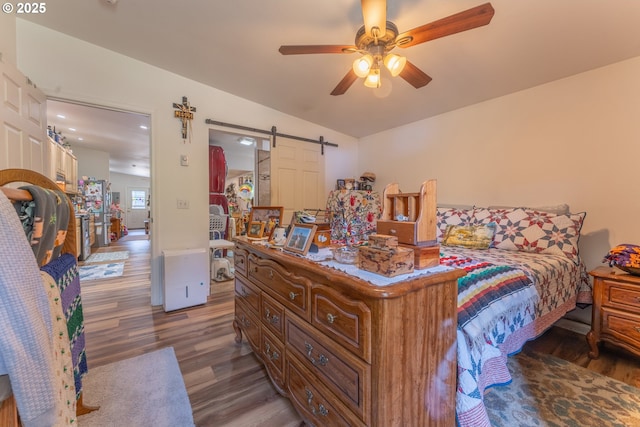 93777 Green Acres Ln, Coos Bay, OR 97420 - bedroom featuring wood finished floors, lofted ceiling, a barn door, and ceiling fan