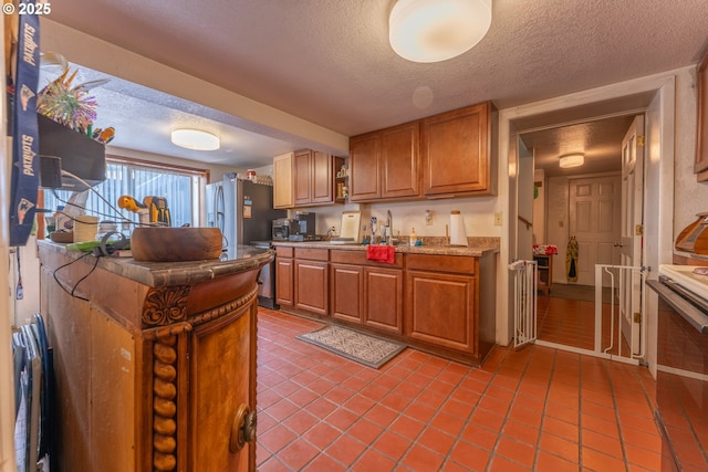 93777 Green Acres Ln, Coos Bay, OR 97420 - kitchen with a textured ceiling, radiator heating unit, light tile patterned floors, light countertops, and brown cabinetry