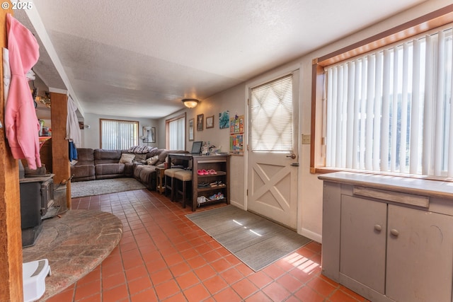 93777 Green Acres Ln, Coos Bay, OR 97420 - living area with light tile patterned floors, a wood stove, and a textured ceiling