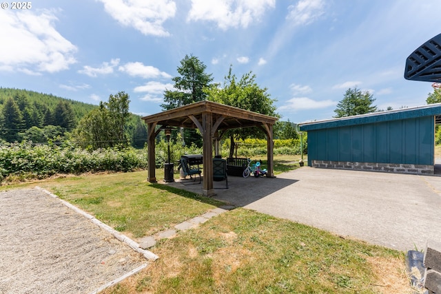 93777 Green Acres Ln, Coos Bay, OR 97420 - view of grassy yard featuring a gazebo, a patio area, and a forest view