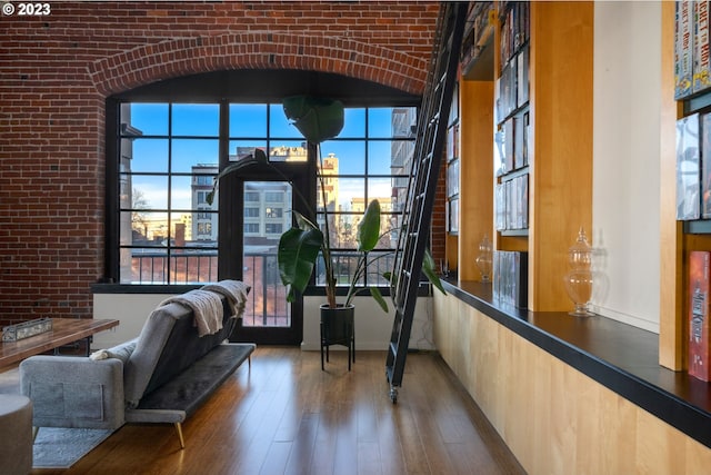 interior space with brick wall and hardwood / wood-style flooring