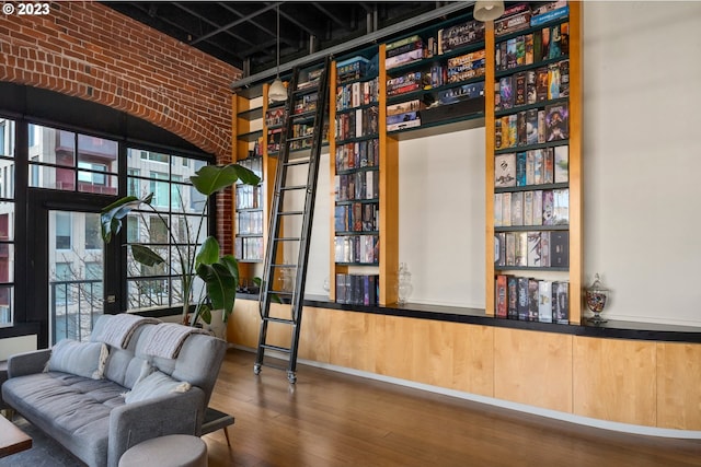 unfurnished room with wood-type flooring and brick wall