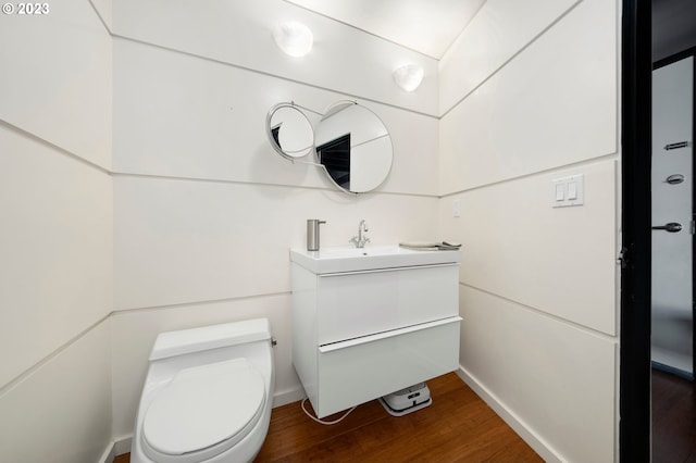 bathroom with hardwood / wood-style floors, vanity, and toilet