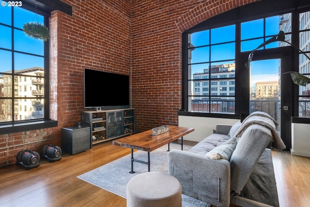 living room with plenty of natural light, light hardwood / wood-style flooring, and a high ceiling