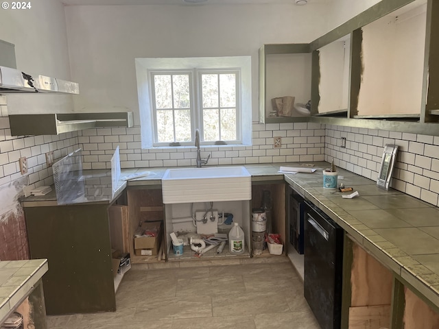 kitchen with tile counters, extractor fan, a sink, and tasteful backsplash