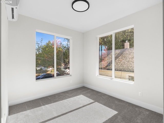 carpeted spare room featuring a wall unit AC and plenty of natural light