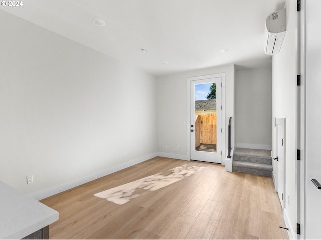 empty room with light hardwood / wood-style floors and a wall mounted AC