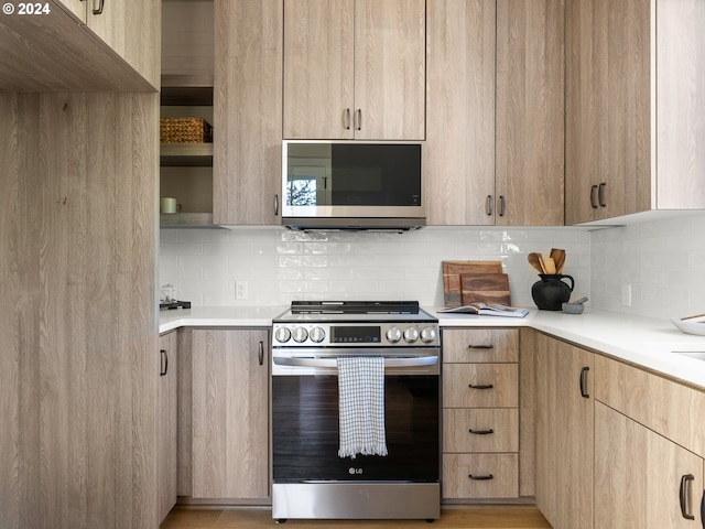 kitchen with appliances with stainless steel finishes, backsplash, and light brown cabinetry