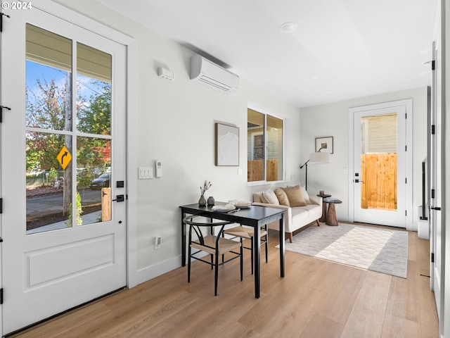 interior space featuring light hardwood / wood-style flooring, a healthy amount of sunlight, and a wall mounted AC