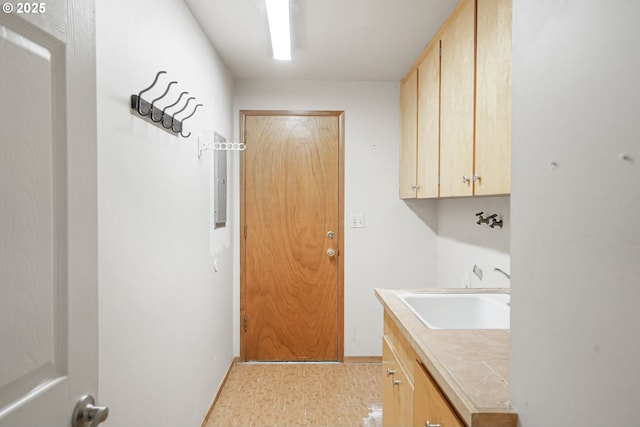 laundry area featuring sink and cabinets