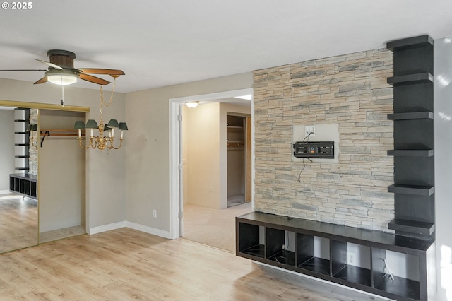 interior space featuring wood-type flooring and ceiling fan with notable chandelier