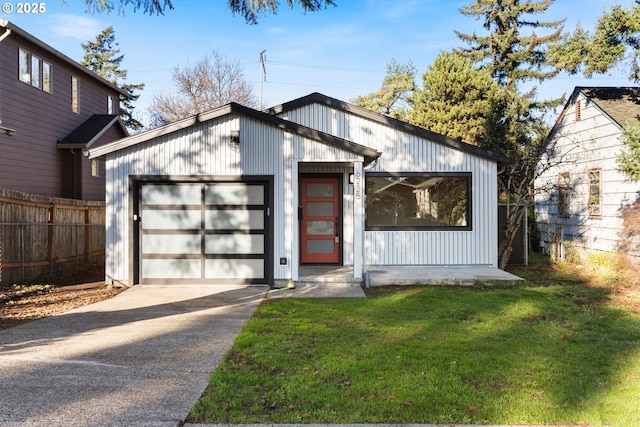 view of front of house featuring a garage, an outbuilding, and a front yard