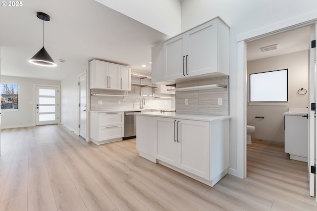 kitchen featuring dishwasher, tasteful backsplash, decorative light fixtures, light hardwood / wood-style floors, and white cabinetry