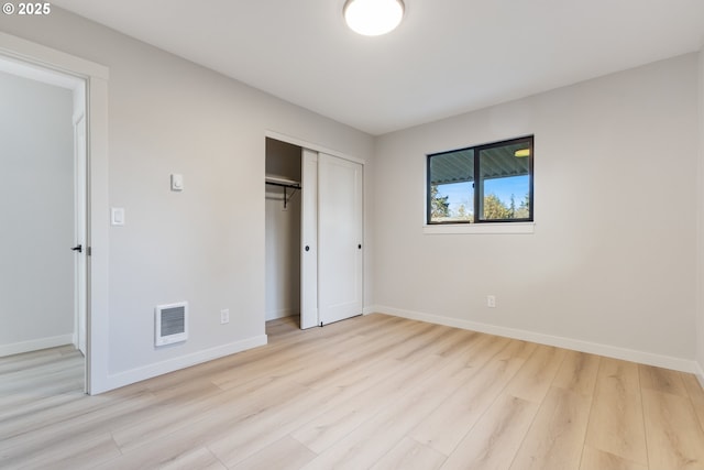 unfurnished bedroom with light hardwood / wood-style floors and a closet