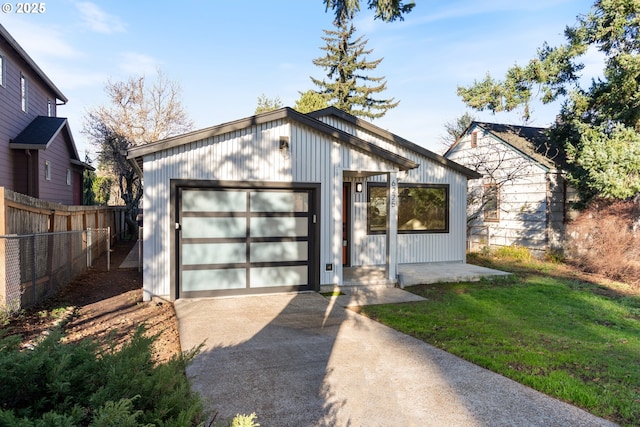 view of front of home featuring a front yard, a garage, and an outdoor structure