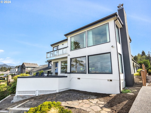 back of property with a balcony and a patio area