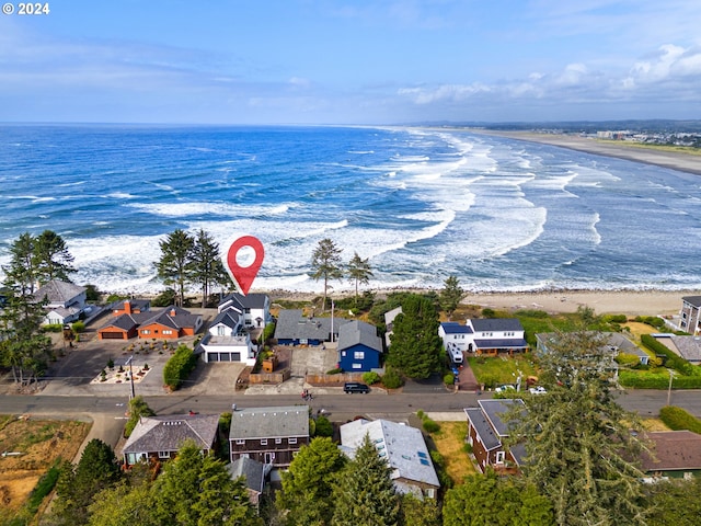 birds eye view of property with a water view and a beach view