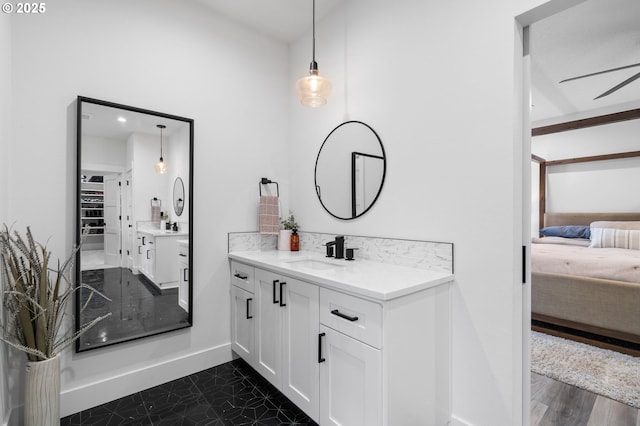 bathroom with vanity, ensuite bathroom, and baseboards