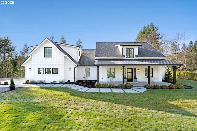 modern farmhouse featuring a front yard, covered porch, a shingled roof, board and batten siding, and metal roof