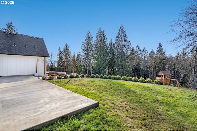 view of yard featuring a forest view and a playground