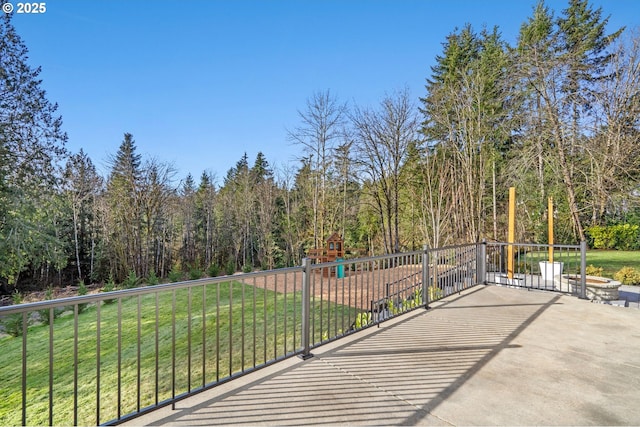 view of patio with a view of trees and a playground