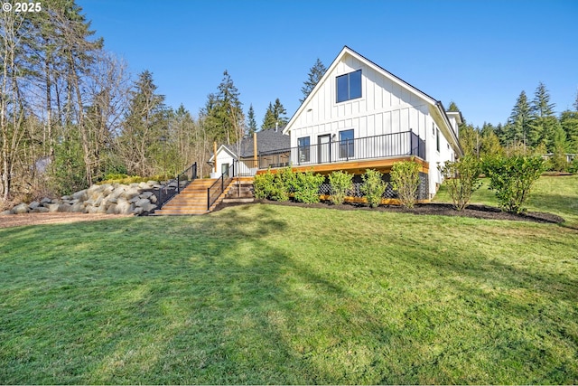 rear view of house featuring a deck, a yard, and board and batten siding