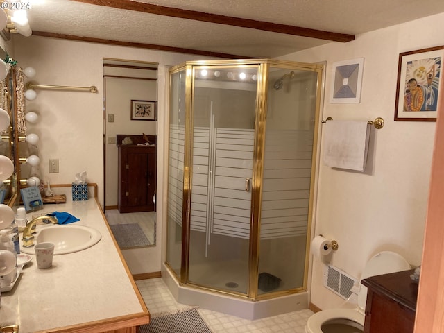 bathroom with a shower with door, vanity, and a textured ceiling