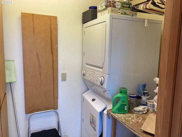 clothes washing area featuring stacked washer and dryer