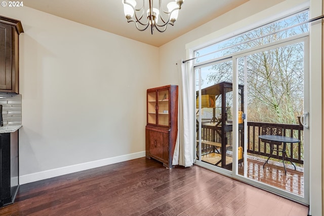 dining space featuring dark wood-type flooring and a chandelier