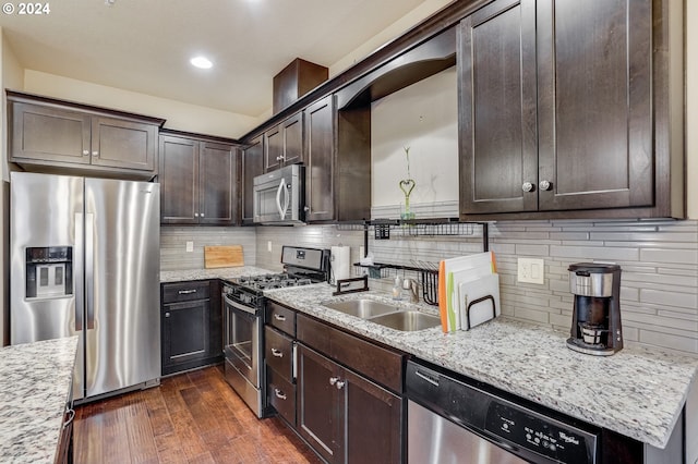 kitchen featuring light stone counters, sink, stainless steel appliances, and dark hardwood / wood-style floors