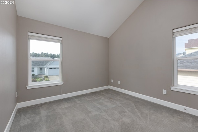 spare room with vaulted ceiling and light carpet