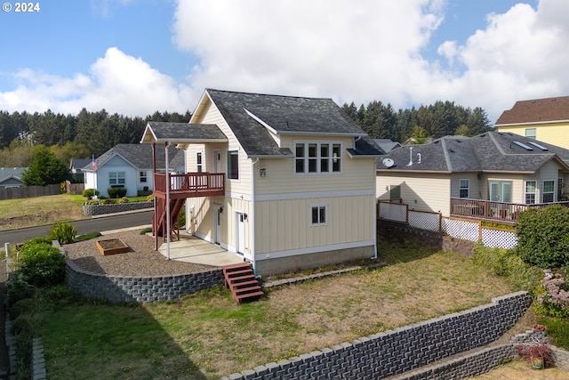 rear view of property featuring a lawn and a wooden deck