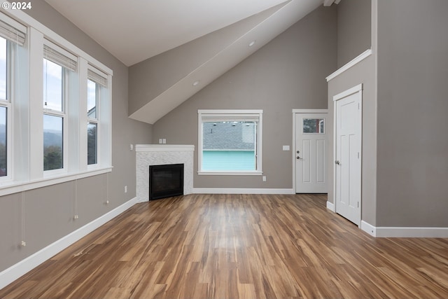 unfurnished living room featuring wood-type flooring and high vaulted ceiling