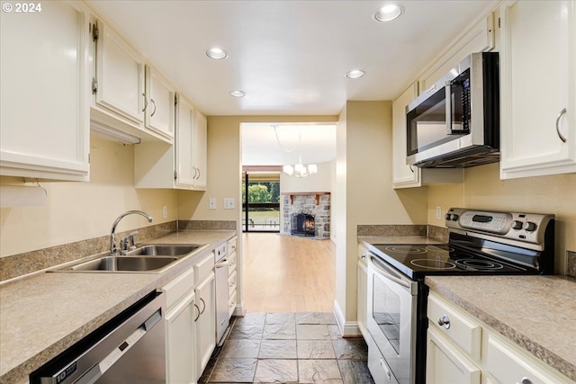 kitchen with appliances with stainless steel finishes, white cabinetry, and sink