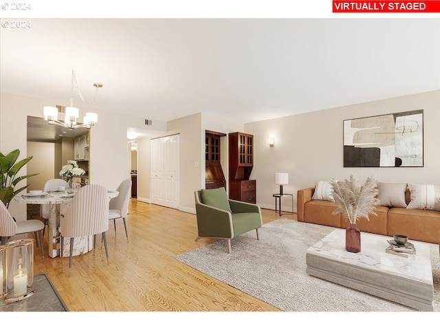 living room featuring light hardwood / wood-style flooring and an inviting chandelier