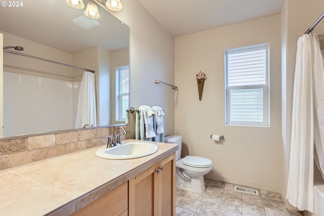 full bathroom featuring vanity, shower / bath combination with curtain, and toilet