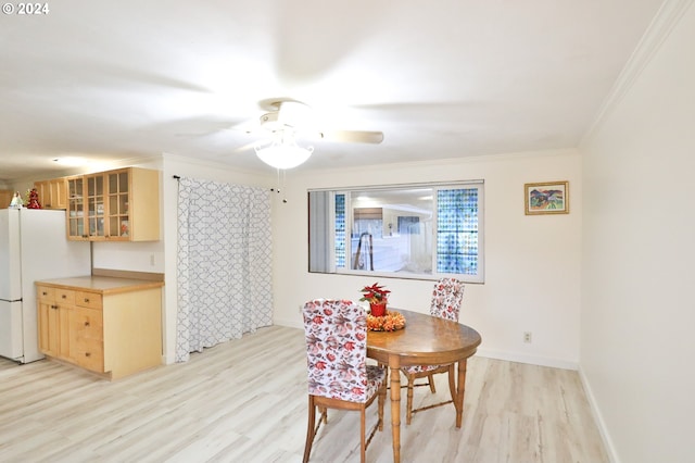 dining room featuring light hardwood / wood-style floors, crown molding, and ceiling fan